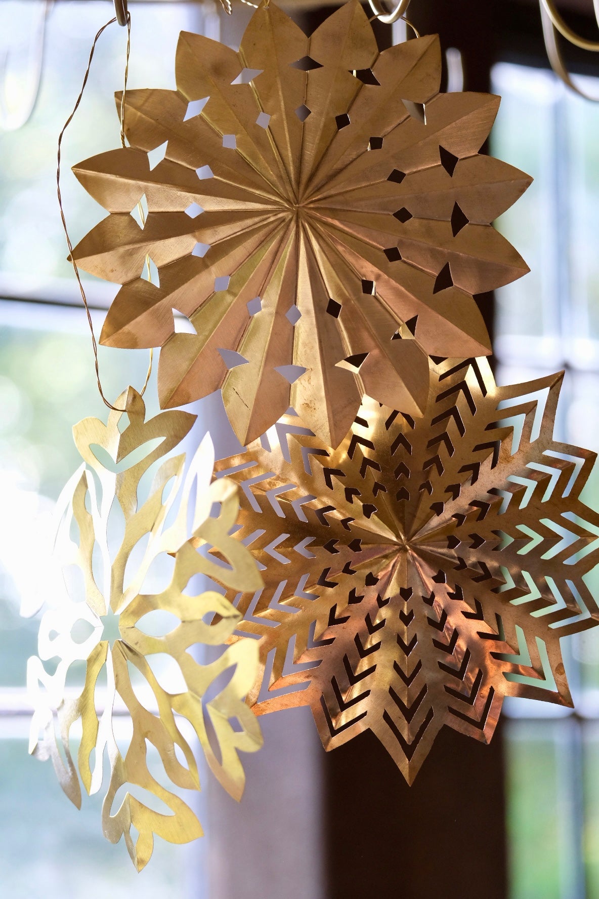 Three hanging decorative brass snowflakes