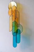 Autumn 1 stained glass hanging sculpture features a modern chandelier with amber golden yellow and teal geometric shapes