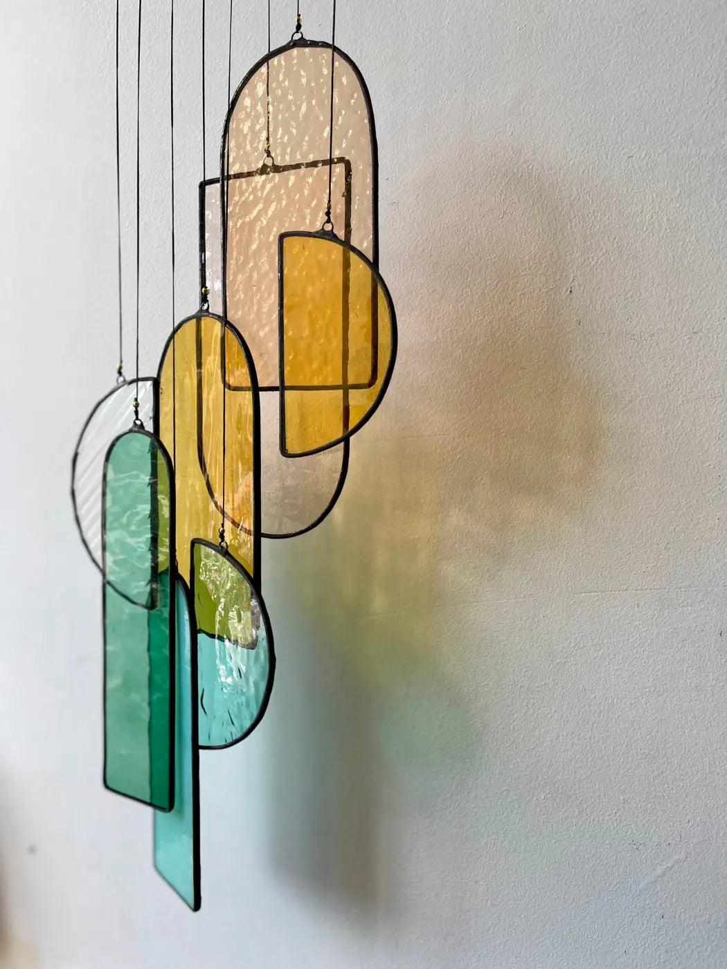 A modern stained glass hanging art piece with amber teal and yellow geometric shapes and black leaded edges autumn 3