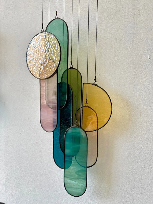 Barra stained glass art with modern oval and elongated teal green pink yellow and gold textured panels hanging display