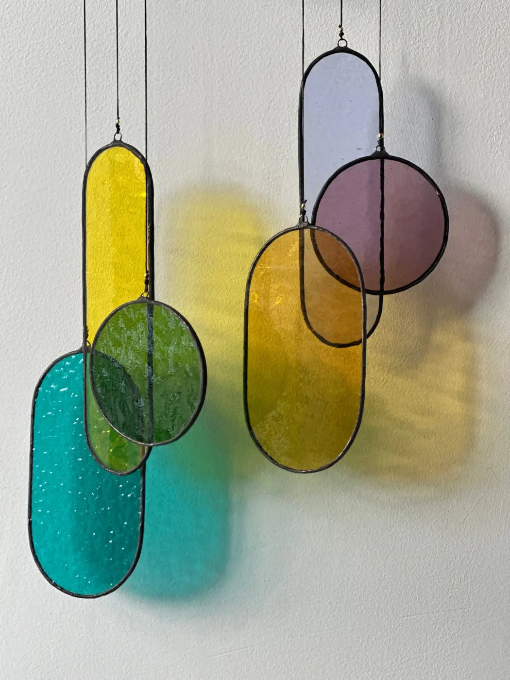 Colorful geometric stained glass hanging ornaments with black metal frames from circa stained glass art collection