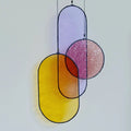 Three hand cut, copper foiled stained glass shapes with a black patina finish, hung with hemp cord from a brass hoop.