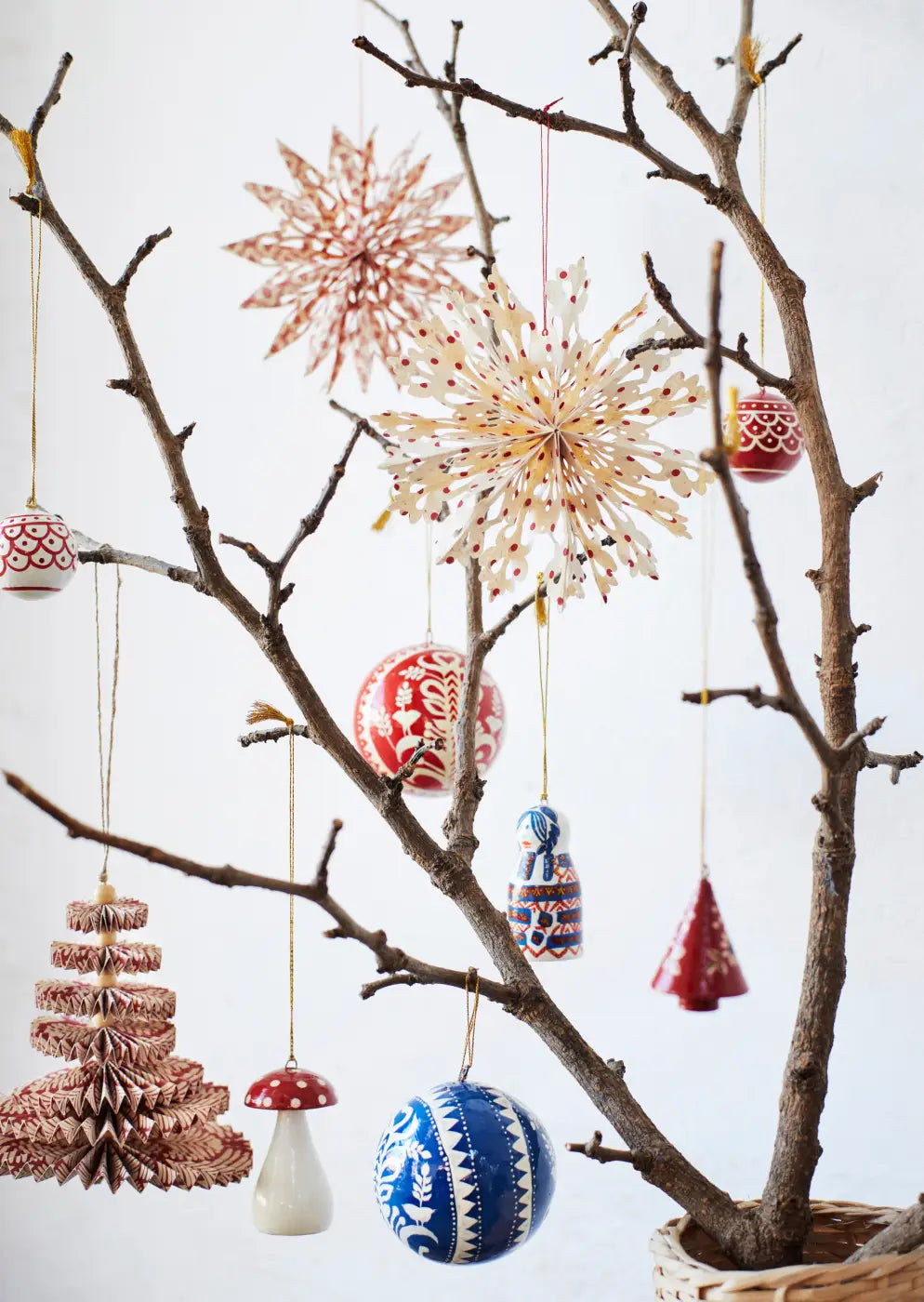 Handmade brass snowflake ornament with a delicate paper star design and subtle red dot accents in a set of 3
