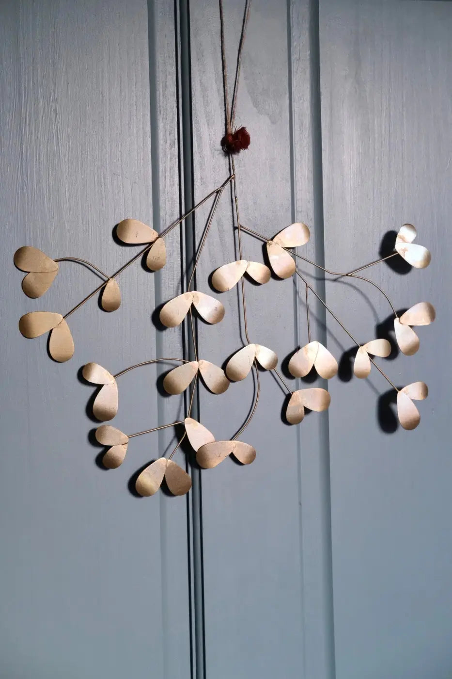 Handmade iron mistletoe wall hanging with delicate gold-toned metal heart-shaped leaves in an organic branching design