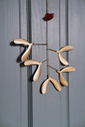 Handmade iron mistletoe small light-colored wooden mobile with a delicate design and a red pom-pom top