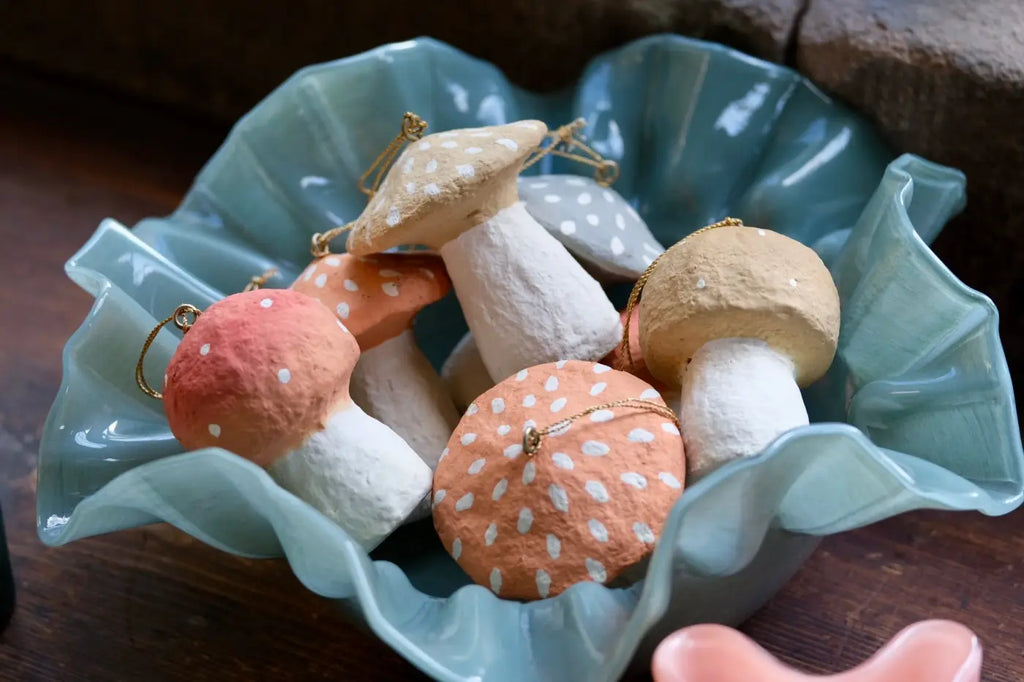 Handmade toadstool decorations hand-painted in soft peach beige and gray with white polka dots and gold hanging loops
