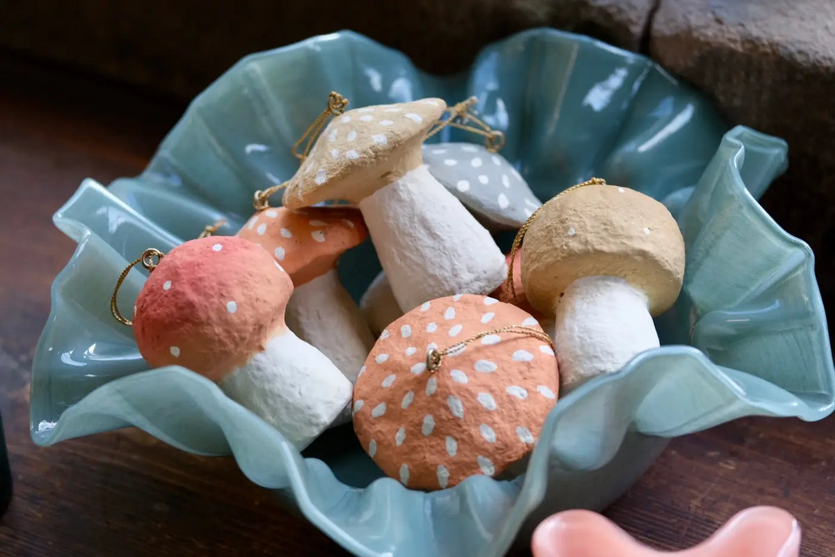 Handmade toadstool decorations hand-painted in soft peach beige and gray with white polka dots and gold hanging loops