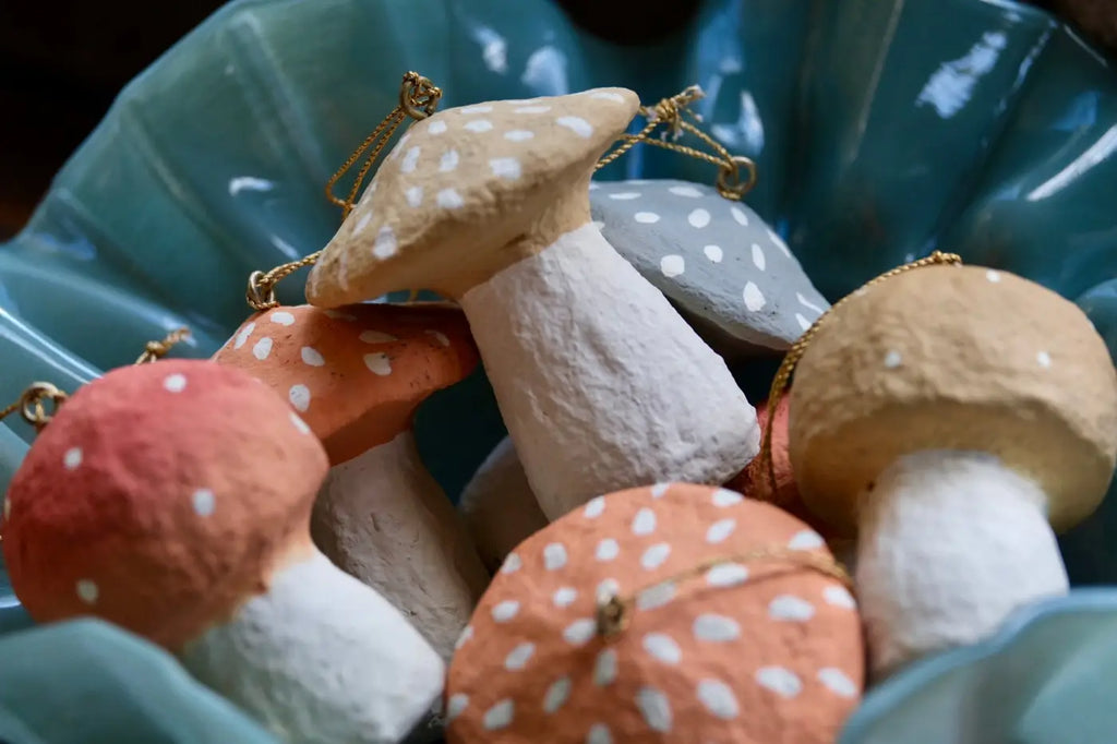 Handmade toadstool decorations hand-painted in earthy tones with white polka dots and gold hanging chains