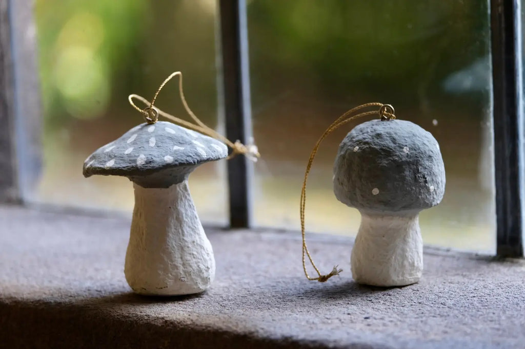 Handmade toadstool decorations featuring handcrafted gray and white mushroom ornaments with speckled caps and gold loops