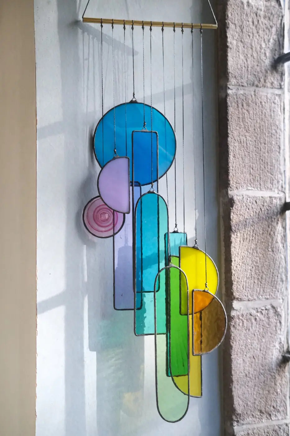 Lawrence 1 stained glass sun catcher artwork with colorful geometric wind chime in blue green yellow and purple hues