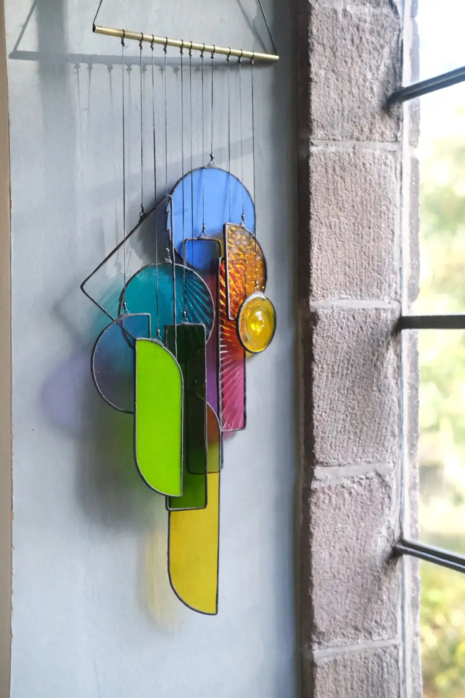 Lawrence 2 stained glass sun catcher artwork features a vibrant geometric wind chime with colorful translucent panels