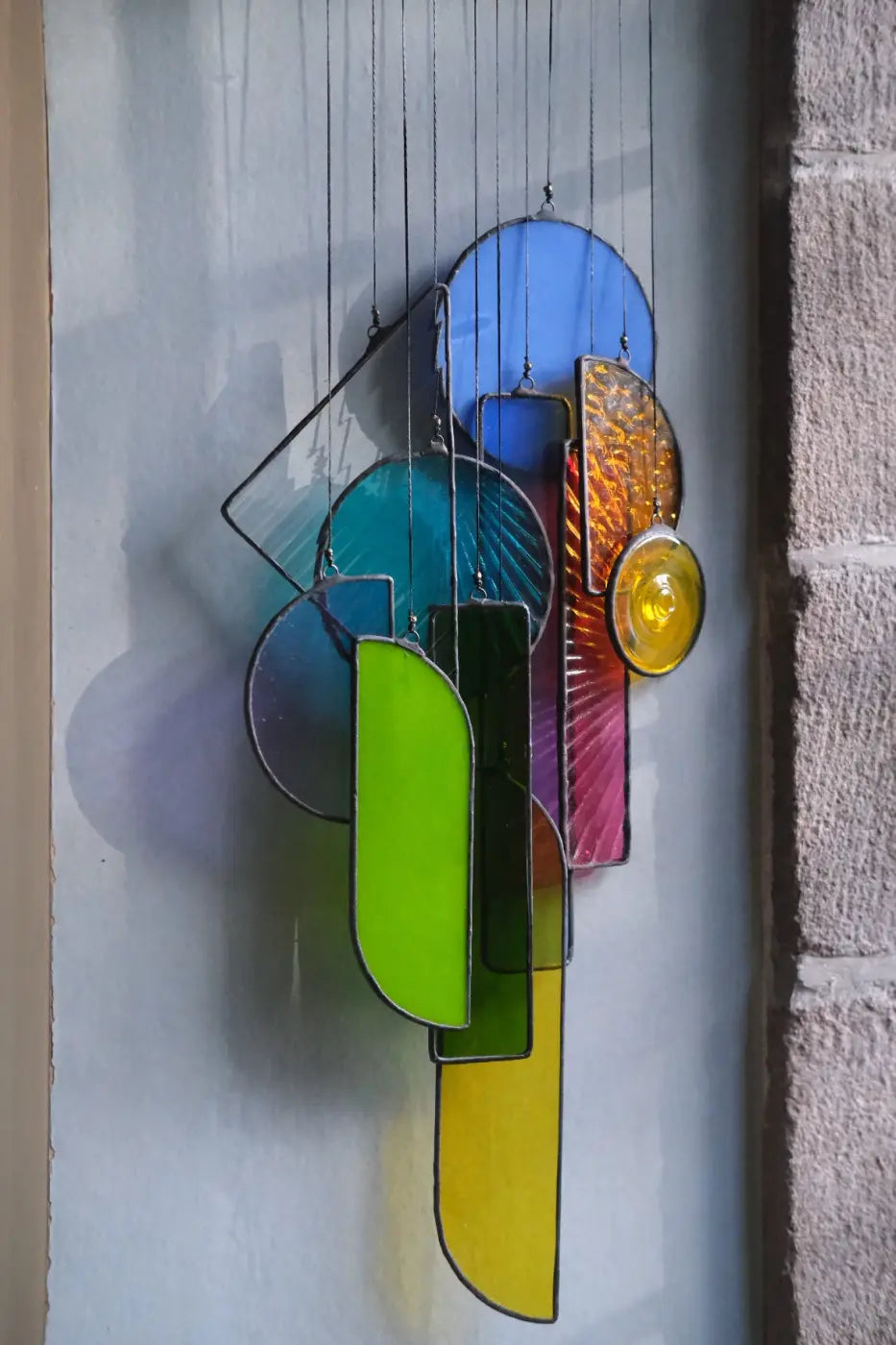 Lawrence 2 stained glass sun catcher wind chime with vibrant blue green yellow orange purple geometric shapes and metallic frame