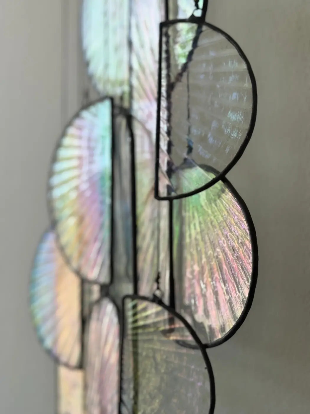 Les Sylphides stained glass art features a delicate iridescent fan-patterned hanging decoration in black metal framing
