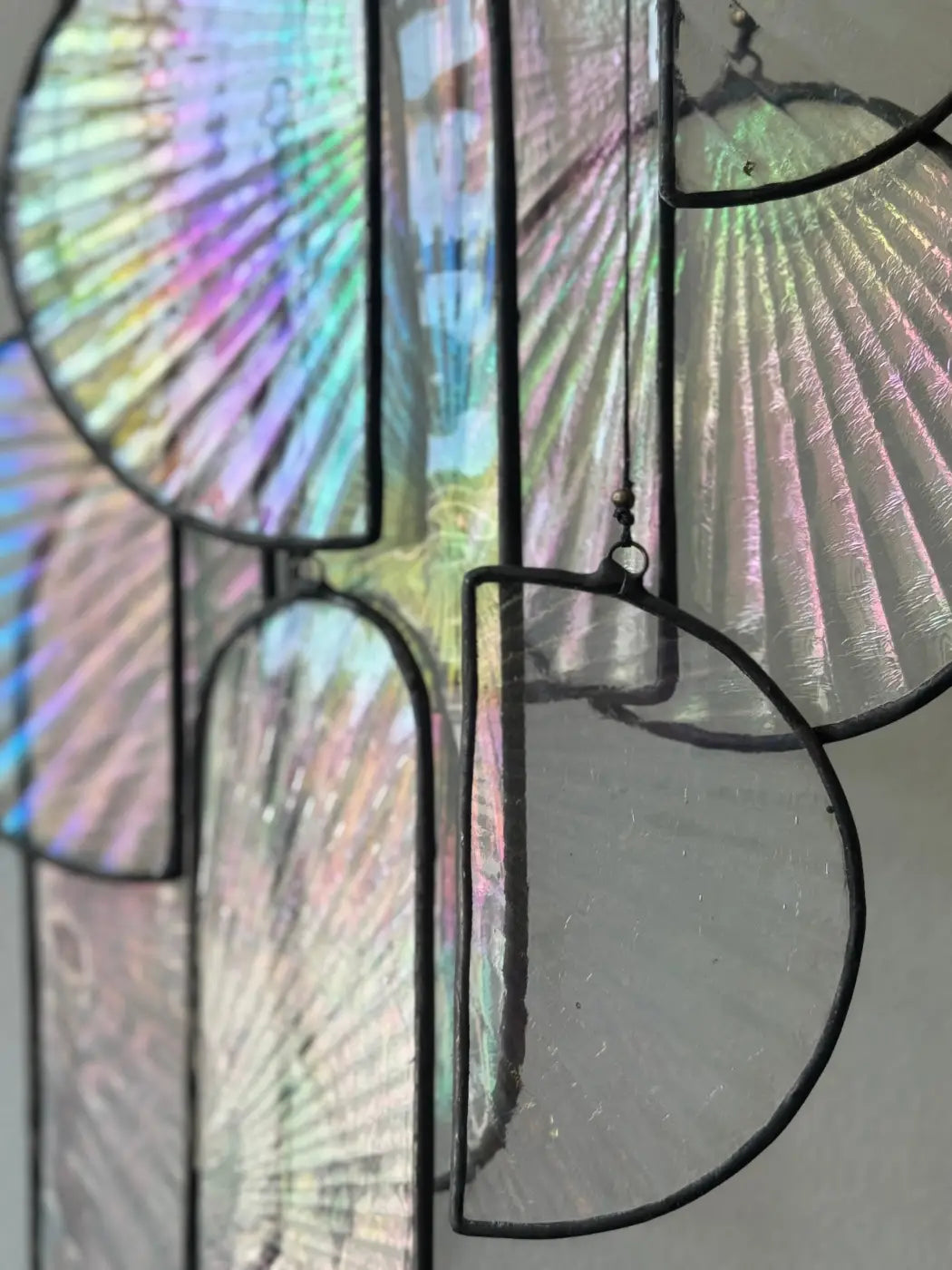 Iridescent iridescent stained glass fan-shaped panels with black metal framing in les sylphides stained glass art