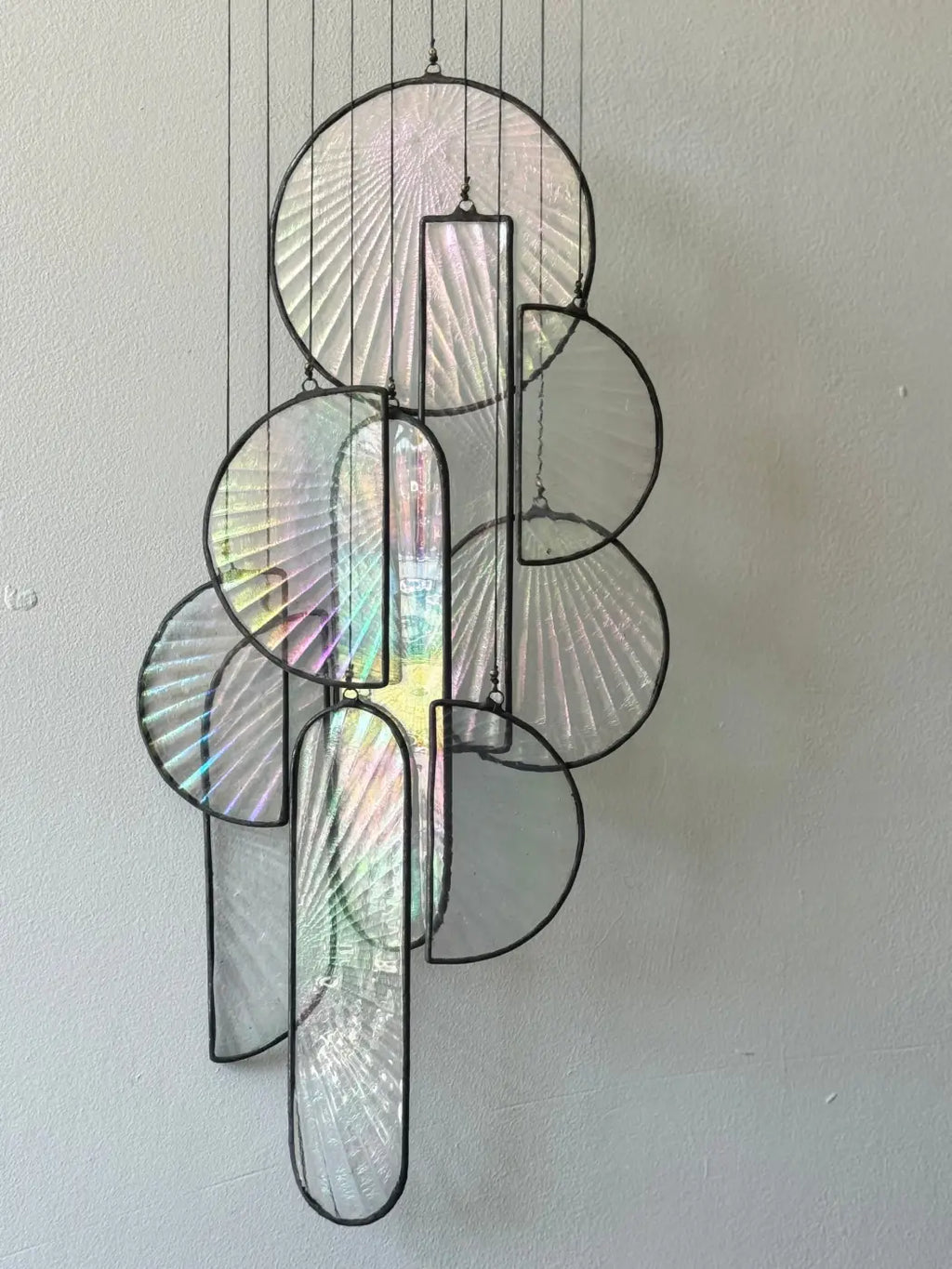 A modern les sylphides stained glass chandelier with iridescent fan patterned circular and rectangular panels in black metal frames