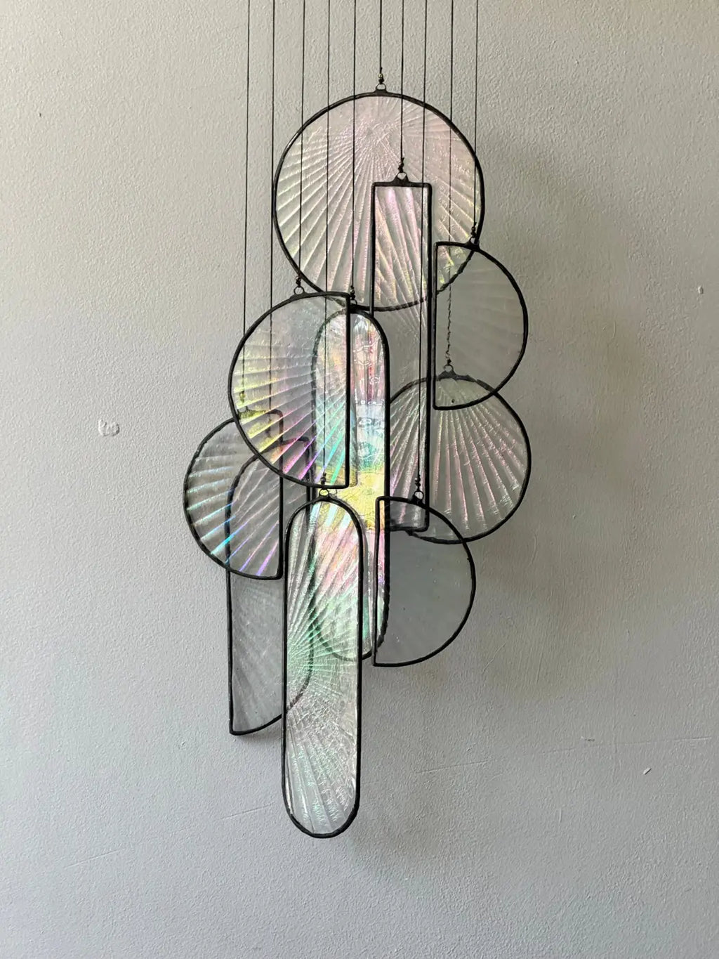 Les Sylphides stained glass art features a modern hanging sculpture with iridescent circular and rectangular panels framed in black metal
