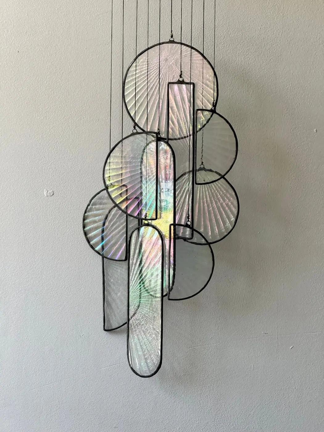 Les Sylphides stained glass art features a modern hanging sculpture with iridescent circular and rectangular panels framed in black metal