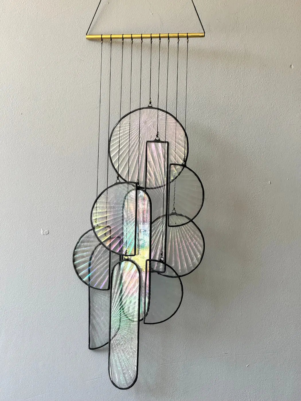 Les Sylphides stained glass art hanging wind chime with iridescent white and pastel fan-shaped panels framed in black metal