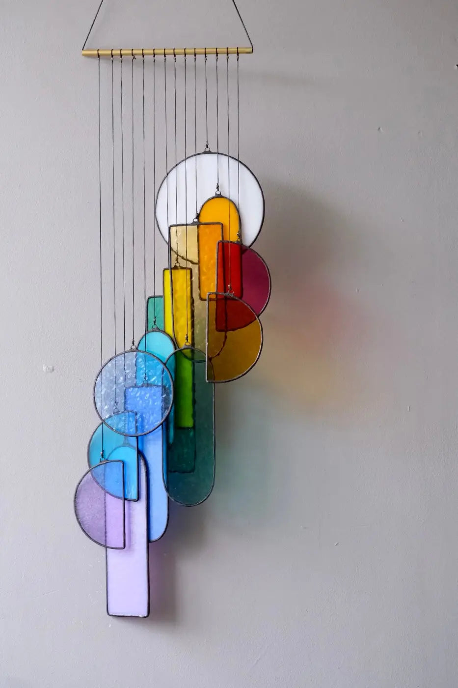 Sagrada stained glass hanging art featuring a colorful wind chime with geometric shapes in vibrant hues