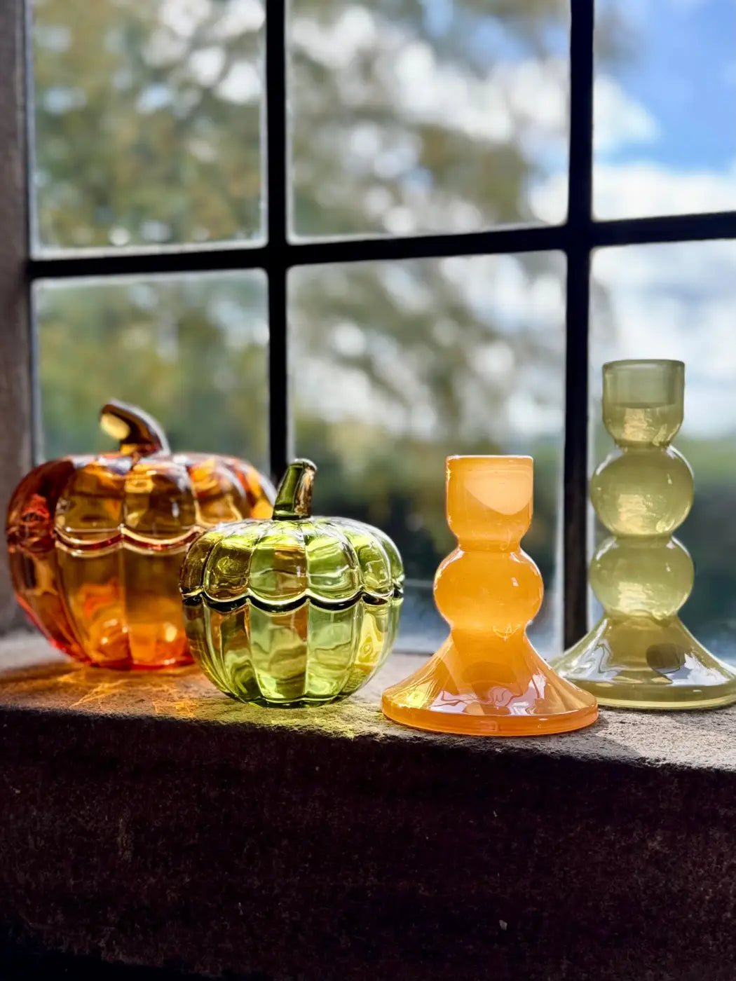 Small bobbin candle holder set with four colorful glass holders and pumpkin decor in amber lime green and orange hues