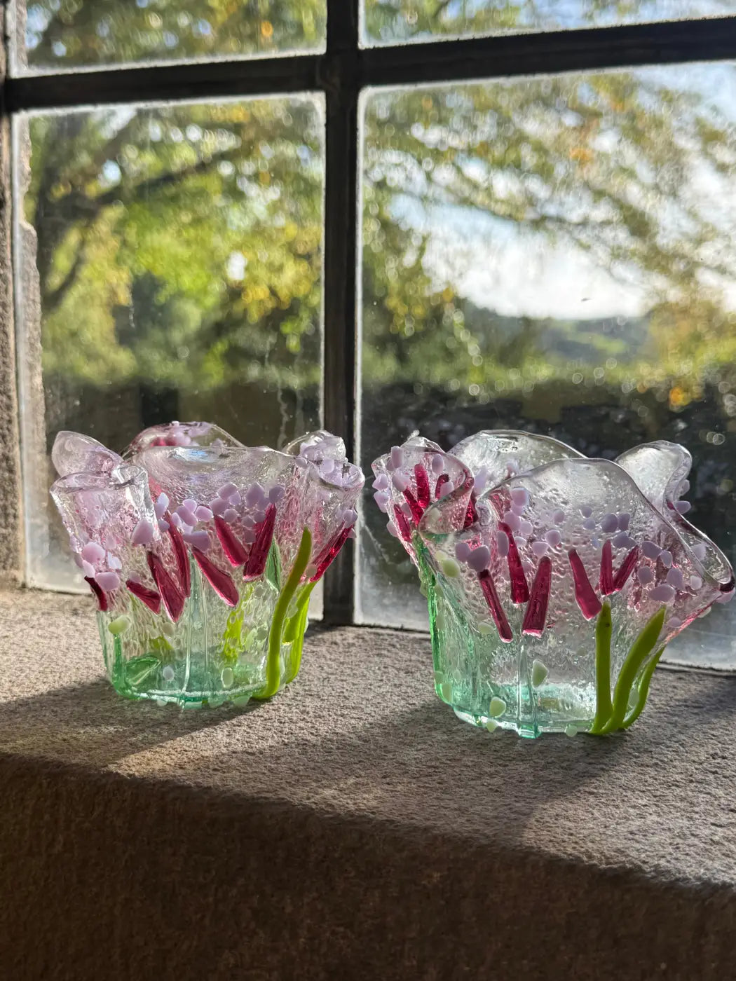 Two translucent glass flower vases with pink and green hues and embedded red petals verbena handmade glass tea-light holders set of 2