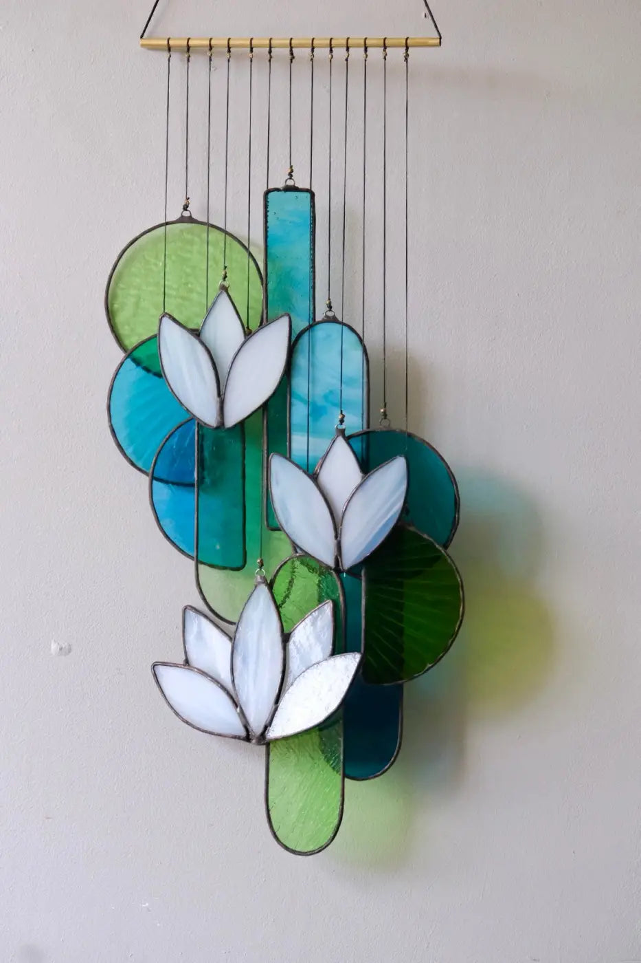 White lotus stained glass hanging art featuring white lotus flowers with green and blue geometric shapes