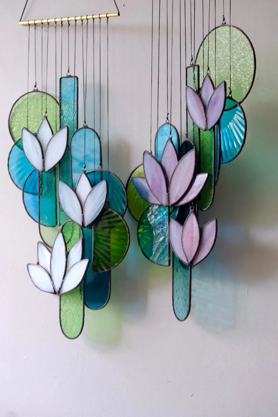 White lotus stained glass hanging art featuring a wind chime with white and pink lotus flowers and colorful circular leaves