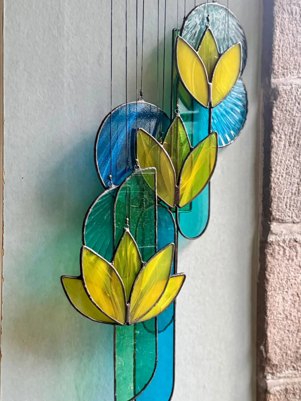 Yellow lotus stained glass hanging art featuring vibrant yellow and green lotus flowers with blue circular accents