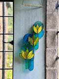 Decorative stained glass panel with leaf design on a light blue background