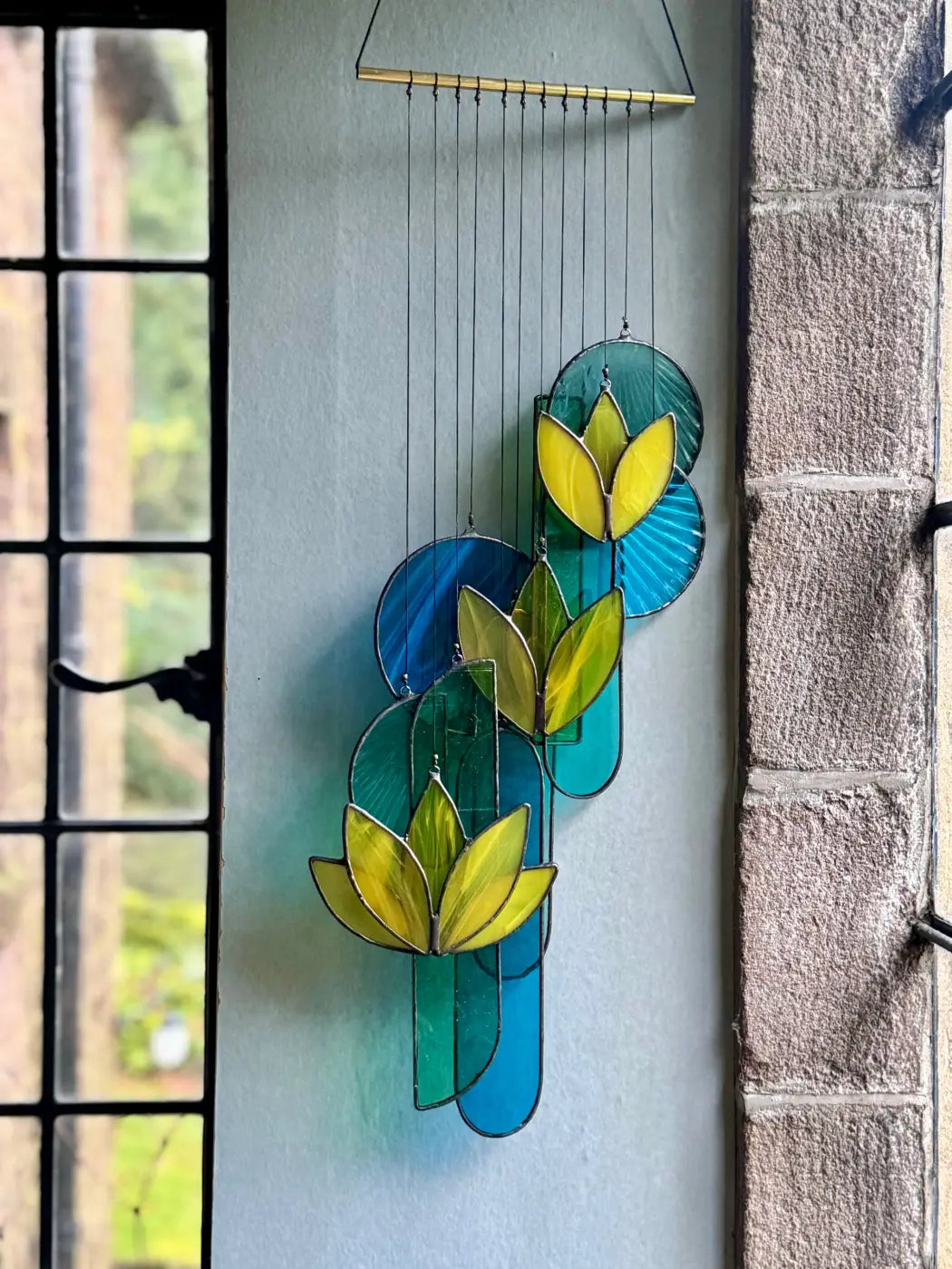 Decorative stained glass panel with leaf design on a light blue background